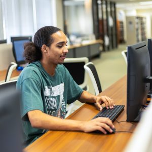 Student using a computer in the library at GLS